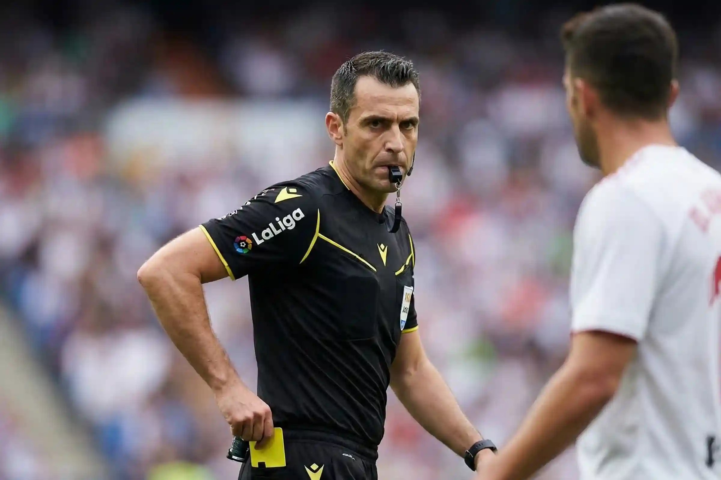 &Aacute;rbitro de f&uacute;tbol preparando tarjeta durante un partido intenso