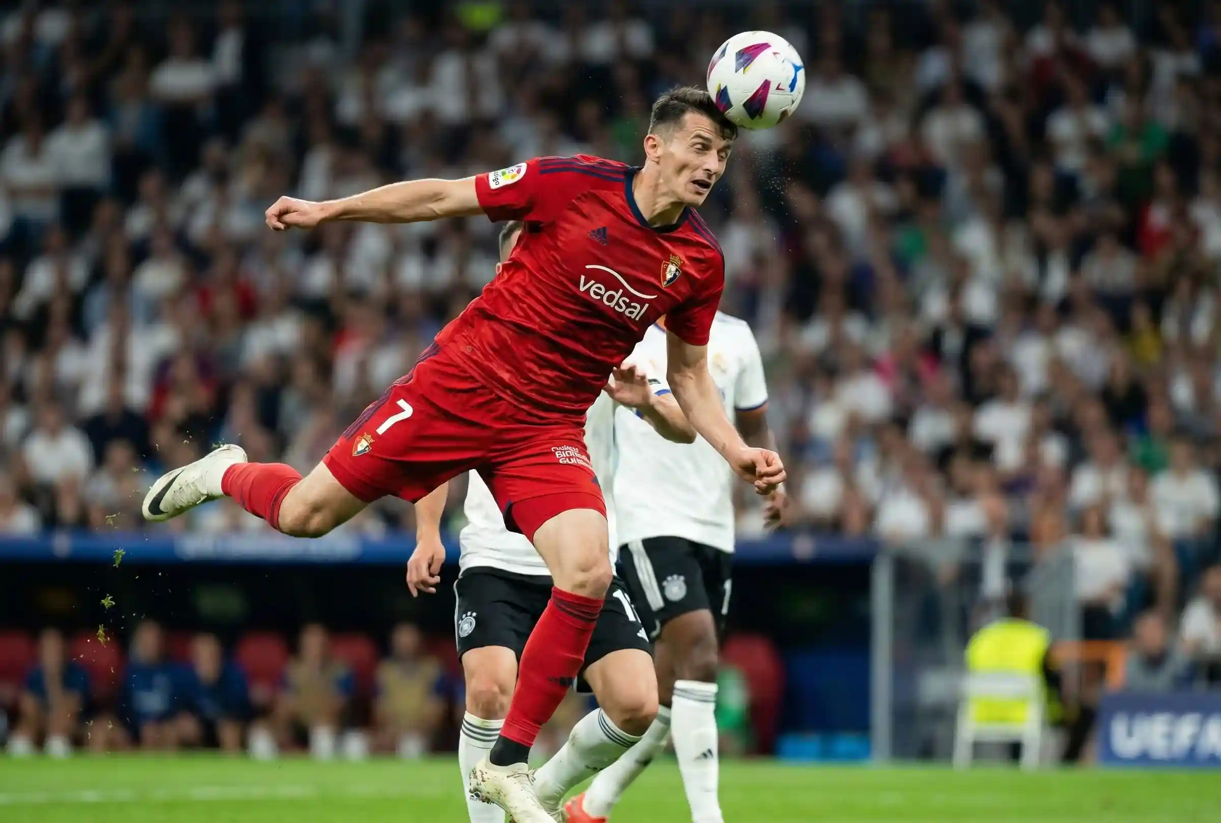 Jugador de f&uacute;tbol rematando de cabeza en el &aacute;rea durante un partido