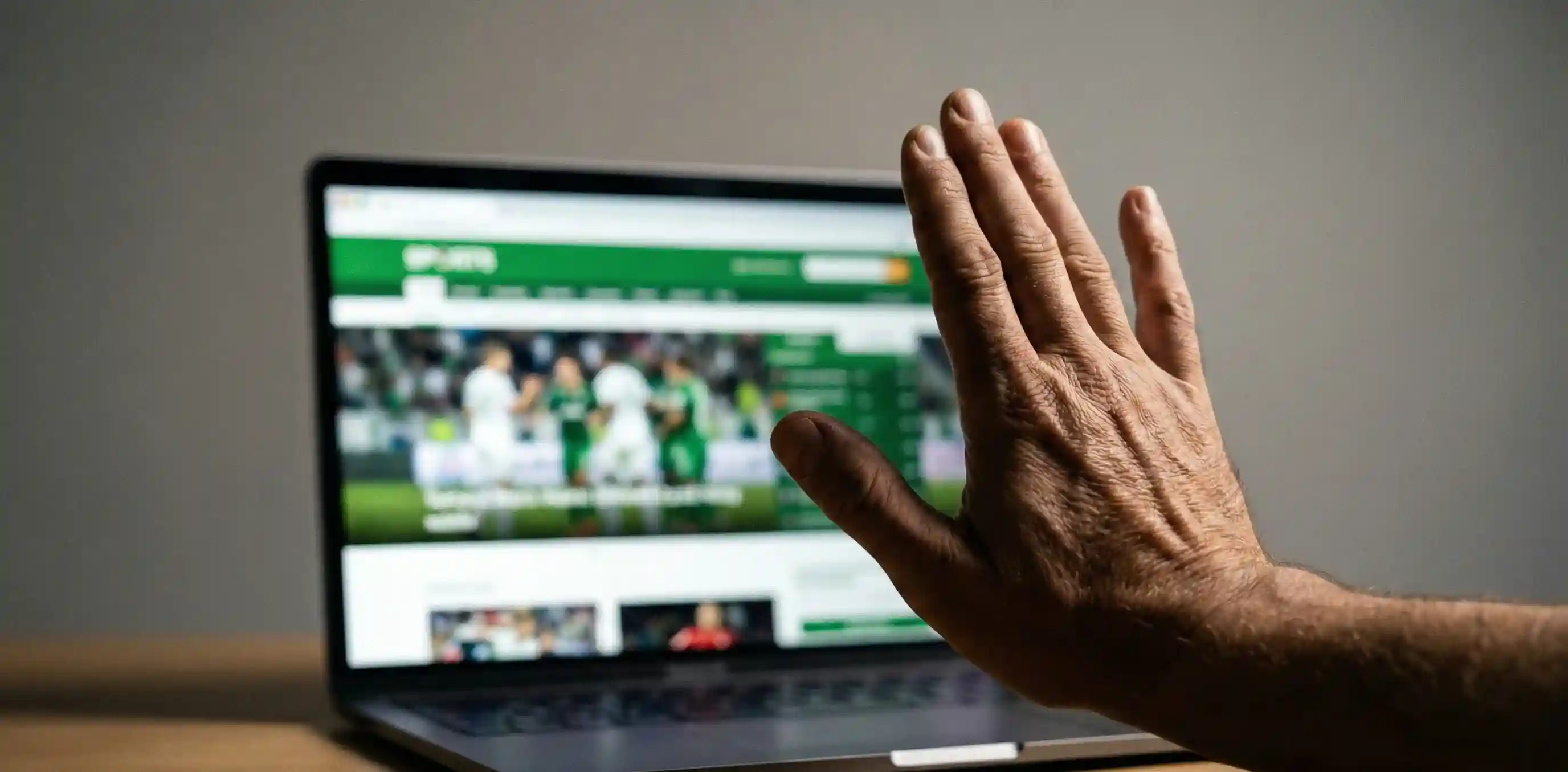 Mano detenida en se&ntilde;al de alto frente a un port&aacute;til con apuestas deportivas