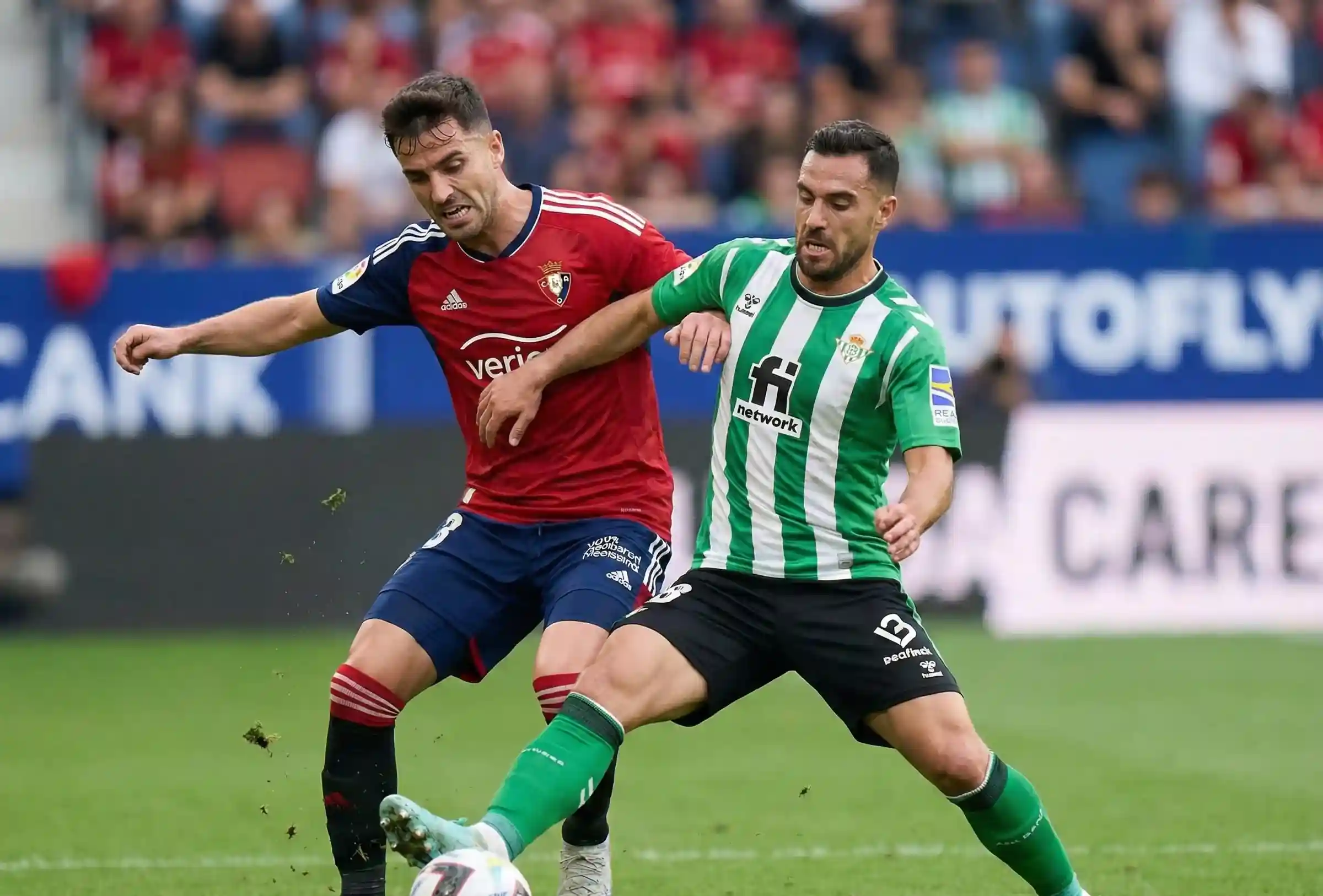 Duelo entre jugadores de Osasuna y un equipo andaluz durante un partido de La Liga
